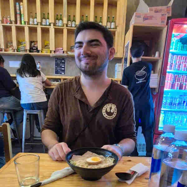 foto de Franco Scalamandré sentado en una mesa con comida sonrriendo